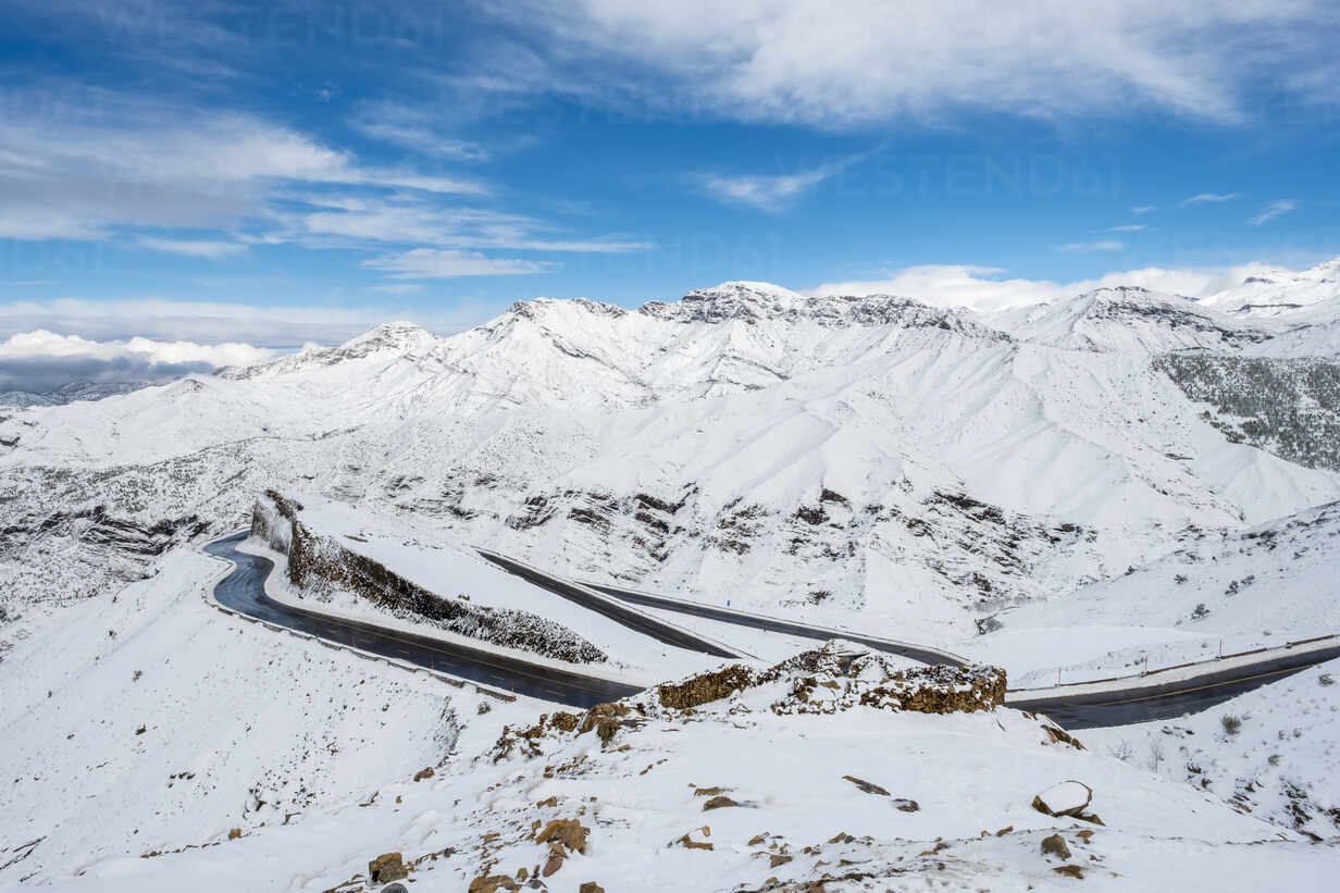 Winding road through Tizi N'Tichka pass in the Atlas Mountains during winter snow.